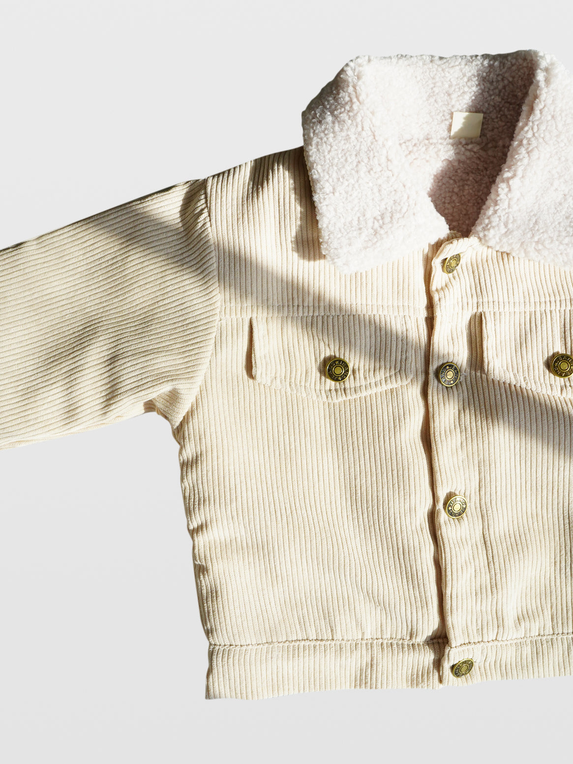 Cream corduroy long sleeve fall autumn winter jacket coat with metal buttons double front pockets and off white sherpa collar and lining western clothes for toddlers baby boy clothes babies boys girls unisex cool kids mom must haves holiday gift guide trendy kids wear essentials made in Los Angeles toddler jacket kids shopping baby boy boutique baby boy clothes boutique kids shopping children’s boutique online shopping for kids kids wear near me baby clothes near me