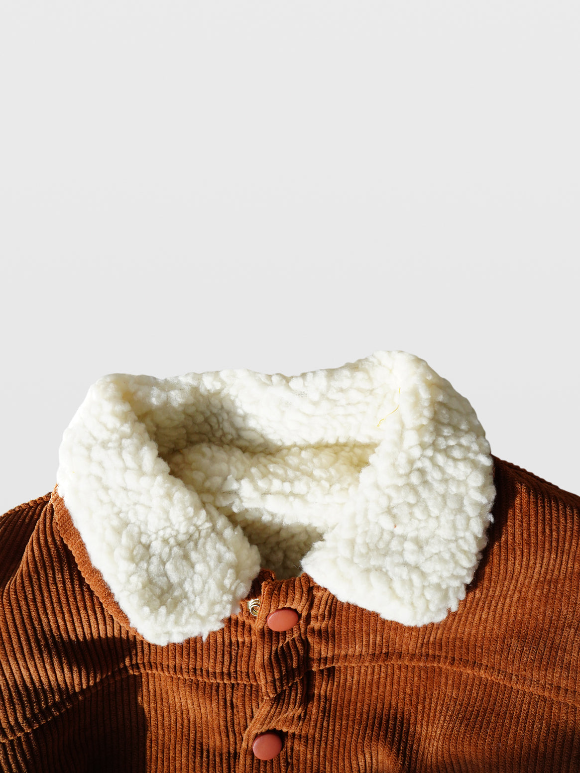 close up of Sherpa collar and lining of Rust color corduroy long sleeve fall autumn winter jacket coat with rust matte coated snaps double front kangaroo pockets and off white sherpa collar and lining for toddlers babies boys girls unisex cool kids mom must haves holiday gift guide trendy kids wear essentials made in Los Angeles 