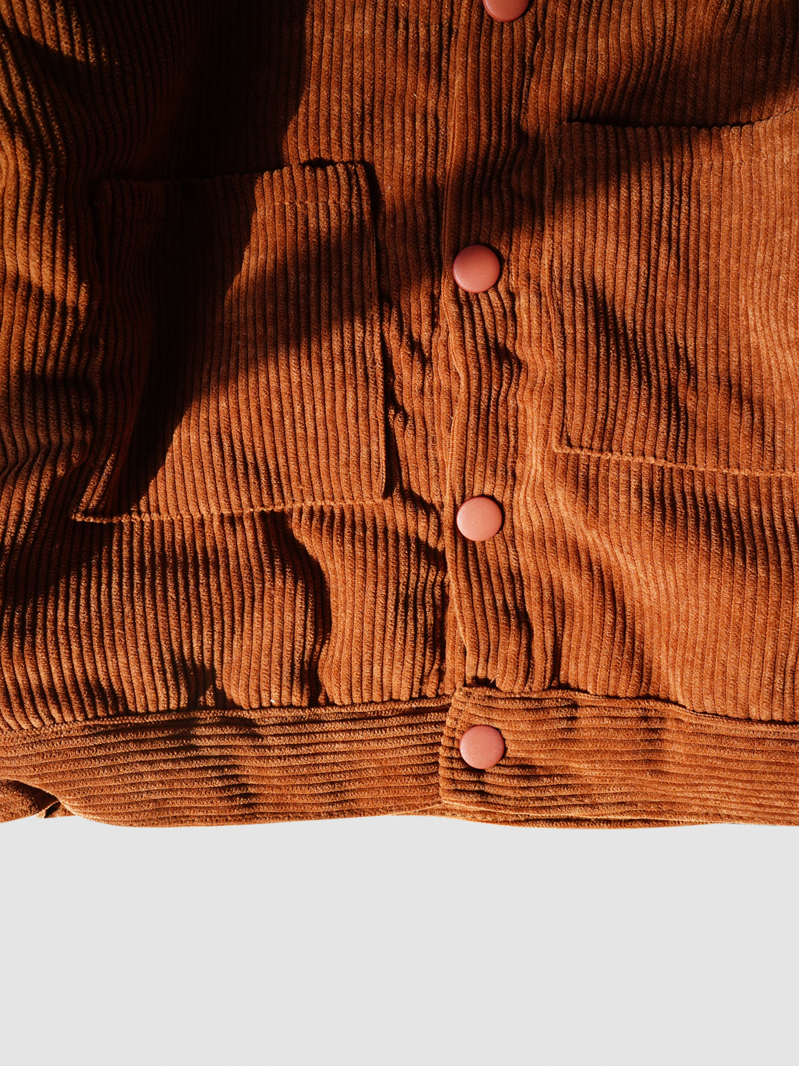 detail close up of rust color coated snaps of Rust color corduroy long sleeve fall autumn winter jacket coat with rust matte coated snaps double front kangaroo pockets and off white sherpa collar and lining for toddlers babies boys girls unisex cool kids mom must haves holiday gift guide trendy kids wear essentials made in Los Angeles 